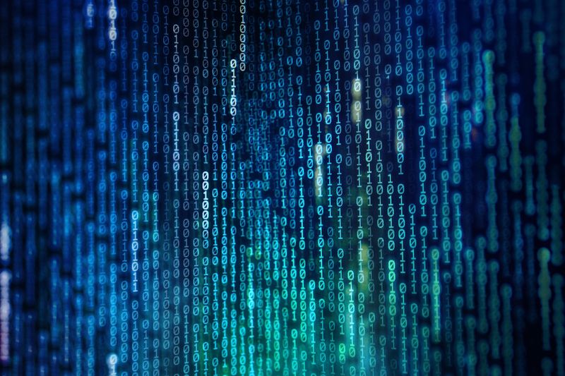 strings of vertical binary numbers in shades of blue on a dark background
