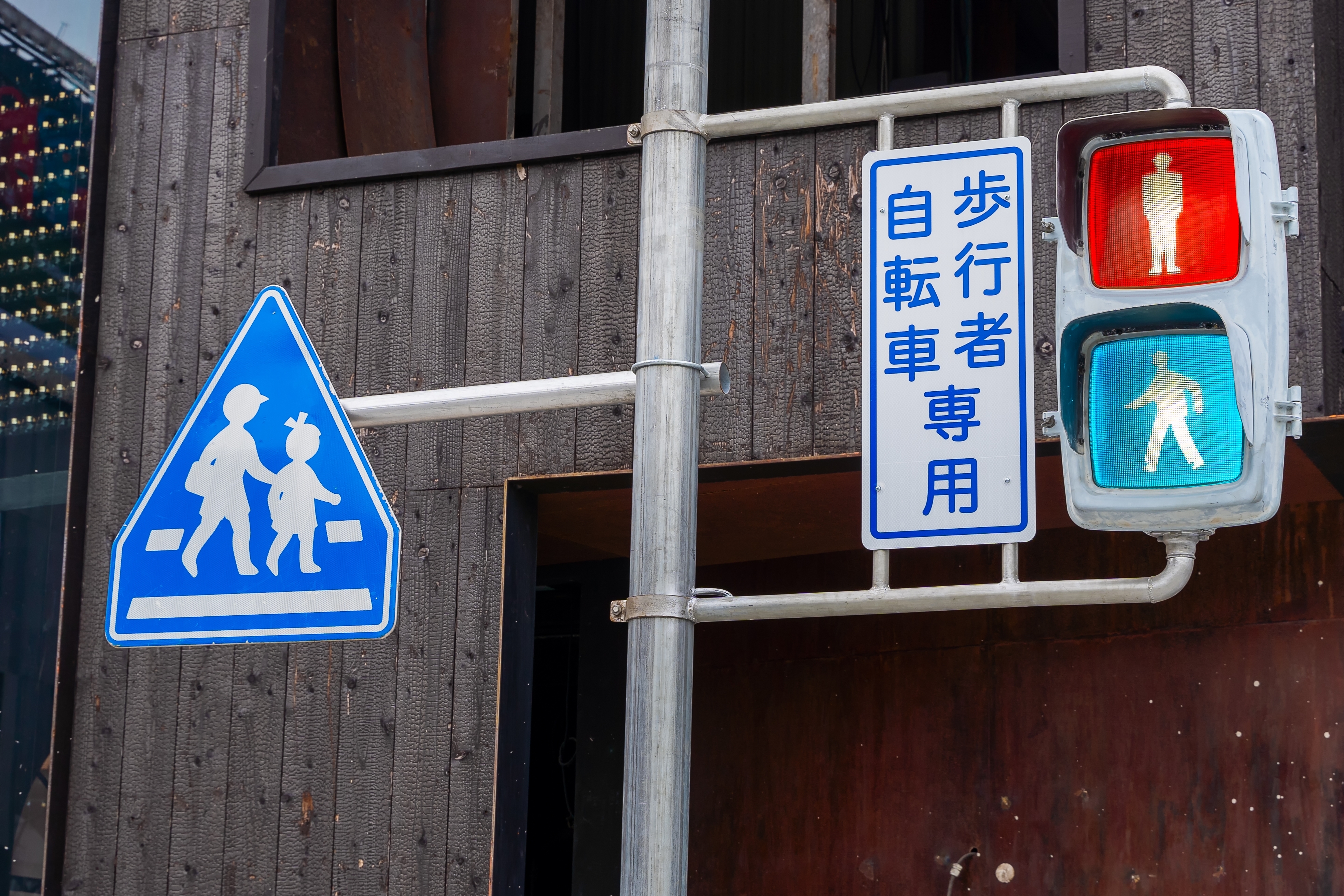 A blue traffic light in Japan at a pedestrian crossing.