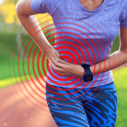 close up photograph of a woman in workout clothing slightly bent over in pain, holding her hand on the side of her abdomen
